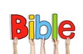 Diverse Hands Holding the Word Bible Royalty Free Stock Photo