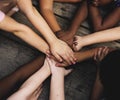 Diverse hands are join together on the wooden table