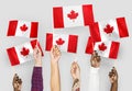 Diverse hands waving flags of Canada