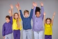 diverse happy children raising their hands, arms looking at camera Royalty Free Stock Photo