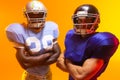 Diverse male american football players wearing helmets with neon orange lighting