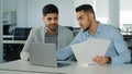 Diverse male employees Arab young colleagues discussing working together, checking emails. Two serious focused East