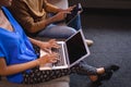 Diverse male and female colleagues working sititng on sofa in office using computer and tablet Royalty Free Stock Photo