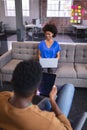 Diverse male and female colleagues working sititng on sofa in office using computer and tablet Royalty Free Stock Photo