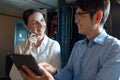 Diverse male and female engineers smiling while using digital tablet in computer server room Royalty Free Stock Photo