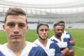 Diverse male rugby players standing together in stadium