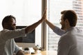 Diverse men colleagues join hands in high five celebrate achievement Royalty Free Stock Photo