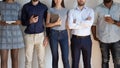 Diverse millennial people stand in row at office together