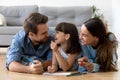 Mother father and daughter lying on floor drawing together Royalty Free Stock Photo