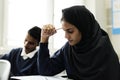 Diverse muslim children studying in classroom