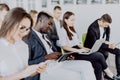 Diverse office people working on mobile phones, corporate employees holding smartphones at meeting. Serious multiracial Royalty Free Stock Photo