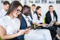 Diverse office people working on mobile phones, corporate employees holding smartphones at meeting. Serious multiracial Royalty Free Stock Photo