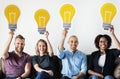 Diverse people carrying light bulb icons Royalty Free Stock Photo