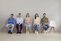 Diverse people on chairs in line before interview