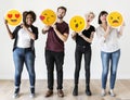 Diverse people holding face emoticon