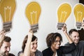 Diverse People holding lightbulb icons together Royalty Free Stock Photo