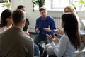 Diverse people seated in circle participating at group therapy session Royalty Free Stock Photo