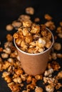Diverse Popcorn in a paper cup against a dark background. Top vi