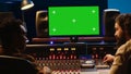 Diverse producers mixing and mastering tracks with mockup display on computer