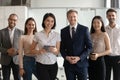 Diverse professional business leaders posing with multicultural workers in office