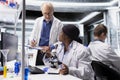 Diverse researchers team analyzes bioscience samples at microscope Royalty Free Stock Photo