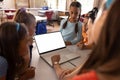 Diverse schoolchildren with female teacher having laptop video call with copy space in classroom Royalty Free Stock Photo