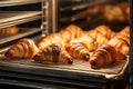 A diverse selection of delicious croissants displayed on a rack, ready for purchase at a local bakery, fresh croissants in rack in