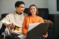 diverse smiling couple shopping online, holding Royalty Free Stock Photo