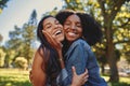 Close up lifestyle portrait of diverse multiracial happy best friends hugging each other and laughing in the park Royalty Free Stock Photo