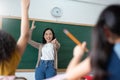 Diverse Student raising their hands up in classroom at international elementary school Royalty Free Stock Photo