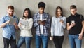 Diverse students with books standing near grey wall Royalty Free Stock Photo