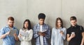 Diverse students with books standing near grey wall Royalty Free Stock Photo
