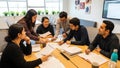Diverse Students Collaborating on Project at Table in Modern Office Space Royalty Free Stock Photo