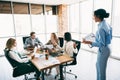 Diverse team collaborating in a workspace during a dynamic meeting, discussing projects and strategies in a bright Royalty Free Stock Photo