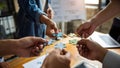 Diverse team hands assembling colorful puzzle pieces together in a collaborative office setting Royalty Free Stock Photo