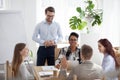 Diverse team laugh brainstorming during flipchart presentation Royalty Free Stock Photo