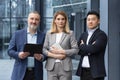 Diverse team man and woman outside office building business people with crossed arms looking Royalty Free Stock Photo