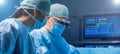 Diverse team of professional medical surgeons perform surgery in the operating room using high-tech equipment. Doctors