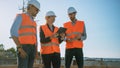 Diverse Team of Specialists Use Tablet Computer on Construction Site. Real Estate Building Project Royalty Free Stock Photo