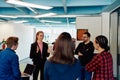 A diverse team of young business people exchanging ideas in a modern startup office Royalty Free Stock Photo