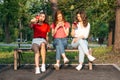 Diverse three girl friends using their phones outdoors. Group gen z young people using mobile smartphone sitting on Royalty Free Stock Photo