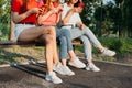 Diverse three girl friends using their phones outdoors. Group gen z young people using mobile smartphone sitting on Royalty Free Stock Photo