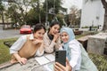 Diverse university students taking a selfie while enjoying their study session outdoors. Royalty Free Stock Photo