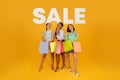 diverse women with shopping bags over background with word sale Royalty Free Stock Photo