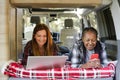 Diverse women working in van during travel