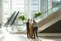 Diverse young business people with tablet talking in the atrium of a modern building Royalty Free Stock Photo