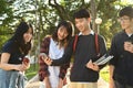 Diverse young college friends talking to etch other while walking after classes in university campus outdoors Royalty Free Stock Photo