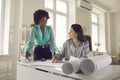 Diverse young multiethnic woman architects discussing blueprints in office Royalty Free Stock Photo