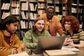 Diverse Young People Collaborating on Project in Library Setting Royalty Free Stock Photo