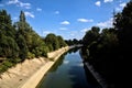 Diversionary channel bordered by trees in the italian countryside on a clear day